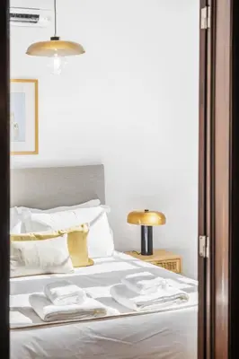 a bed with white sheets and white pillows at Zino Apartment B - By Wehost in Funchal