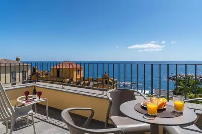 a balcony with a table and chairs and the ocean at OurMadeira - Fort of Old Town Apartments in Funchal