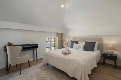 a bedroom with a white bed and a piano at OurMadeira - Fort of Old Town Apartments in Funchal