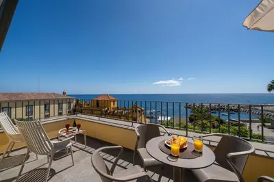 a balcony with a table and chairs and the ocean at OurMadeira - Fort of Old Town Apartments in Funchal