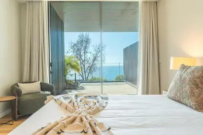 a bedroom with a large bed and a large window at Monumental Sea&Sky by Atlantic Holiday in Funchal