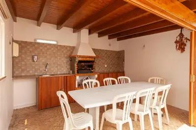 a kitchen with a white table and white chairs at Western Mos Guesthouse in Lagos