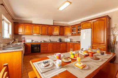 a kitchen with wooden cabinets and a table with food on it at Western Mos Guesthouse in Lagos