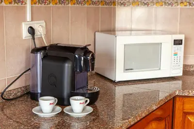 a coffee maker and two cups on a kitchen counter at Western Mos Guesthouse in Lagos