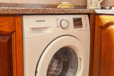 a washing machine in a kitchen under a counter at Western Mos Guesthouse in Lagos