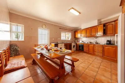 a kitchen with a wooden table and a dining room at Western Mos Guesthouse in Lagos