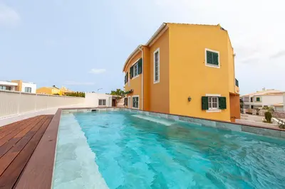 a house with a swimming pool next to a building at Western Mos Guesthouse in Lagos