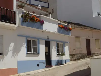 a white building with flower boxes on it at Sea Studio Apartment in Budens