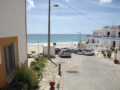 a street with cars parked next to a beach at Sea Studio Apartment in Budens