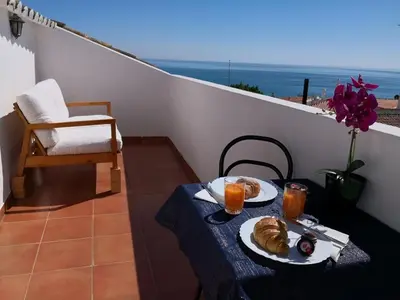 a table with two plates of food on a balcony at Sea Studio Apartment in Budens