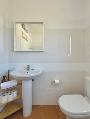 a white bathroom with a sink and a toilet at Casa Sul in Sagres