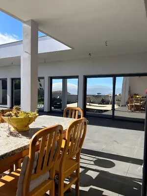 a dining room with a table and chairs on a balcony at Paraiso Madeira - Suites in Gaula
