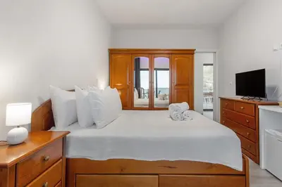 a bedroom with a bed with a television and a dresser at Paraiso Madeira - Suites in Gaula