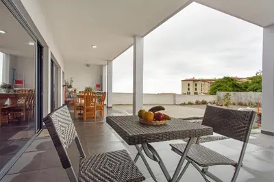 a patio with chairs and a table on a building at Paraiso Madeira - Suites in Gaula