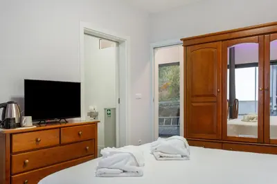 a bed with white sheets and pillows and two lamps at Paraiso Madeira - Suites in Gaula