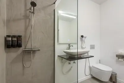 a bedroom with a tv and a bed with towels at Paraiso Madeira - Suites in Gaula