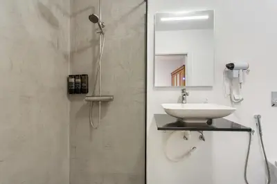 a bathroom with a shower and a sink and a toilet at Paraiso Madeira - Suites in Gaula