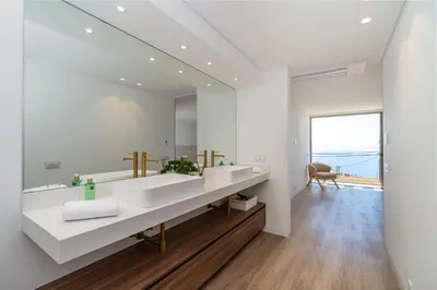 a bathroom with two sinks and a large mirror at Villa das Neves in Estreito da Calheta