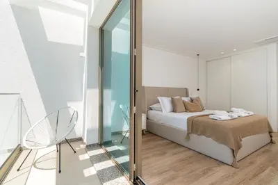 a bedroom with a bed and a glass wall at Villa das Neves in Estreito da Calheta