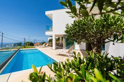 a villa with a swimming pool and a house at Villa das Neves in Estreito da Calheta