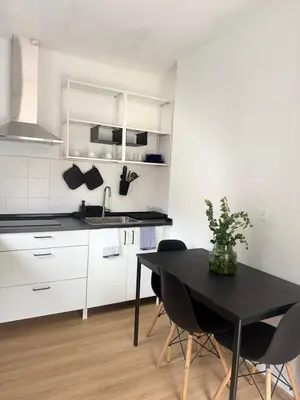 a kitchen with a black table and chairs in it at Casa das Grutas in São Vicente