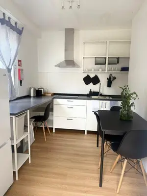 a kitchen with white cabinets and a black table at Casa das Grutas in São Vicente