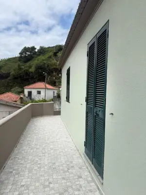 an open door on the side of a white building at Casa das Grutas in São Vicente