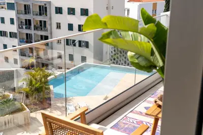 a balcony with a swimming pool on top of a building at Funchal Bay Apartment by Amazing Madeira in Funchal