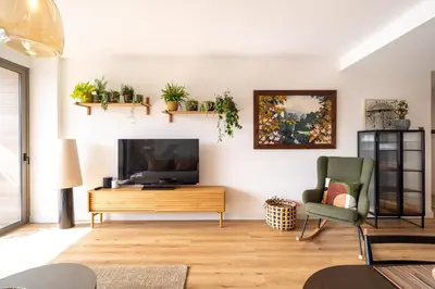 a living room with a flat screen tv and plants on the wall at Funchal Bay Apartment by Amazing Madeira in Funchal