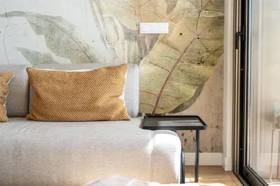 a couch with a pillow and a side table at Funchal Bay Apartment by Amazing Madeira in Funchal