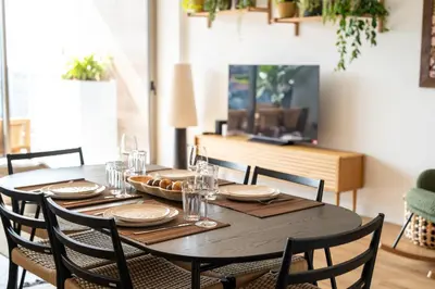 a dining room table with chairs and a table with glasses at Funchal Bay Apartment by Amazing Madeira in Funchal