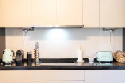 a kitchen with white cabinets and a counter top at Funchal Bay Apartment by Amazing Madeira in Funchal