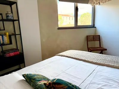 a bedroom with a bed with a window and a chair at Funchal Bay Apartment by Amazing Madeira in Funchal