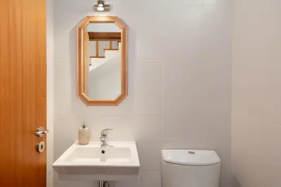 a bathroom with a sink and a toilet and a mirror at Moradia Felicidade Rocha PXO by An Island Apart in Porto Santo
