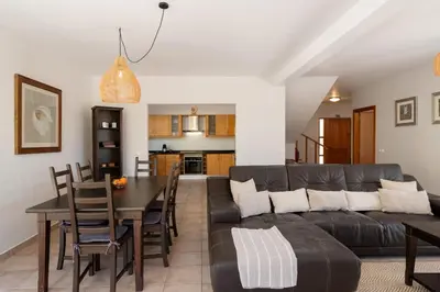 a living room with a black leather couch and a table at Moradia Felicidade Rocha PXO by An Island Apart in Porto Santo