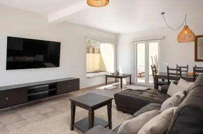 a living room with a couch and a flat screen tv at Moradia Felicidade Rocha PXO by An Island Apart in Porto Santo