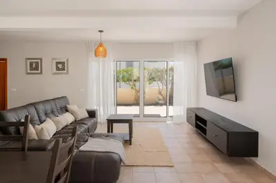 a living room with a couch and a tv at Moradia Felicidade Rocha PXO by An Island Apart in Porto Santo