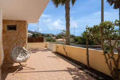 a balcony with a chair and palm trees at Moradia Felicidade Rocha PXO by An Island Apart in Porto Santo