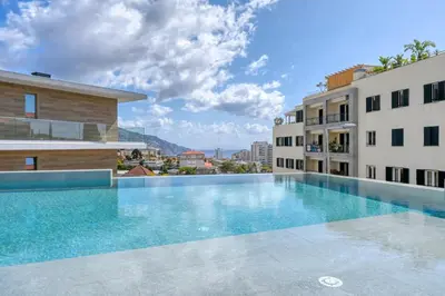 a swimming pool in the middle of two buildings at The Place Funchal View, a Home in Madeira in Funchal