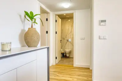 a white kitchen with a plant in a vase at The Place Funchal View, a Home in Madeira in Funchal