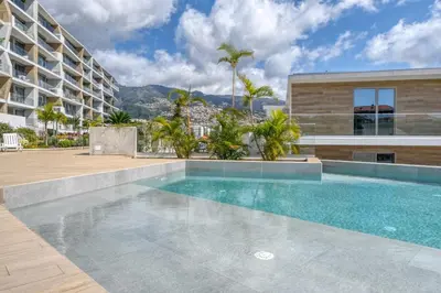 a swimming pool in front of a building at The Place Funchal View, a Home in Madeira in Funchal