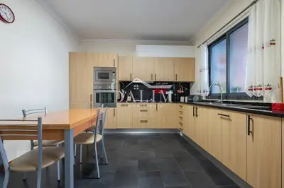 a kitchen with wooden cabinets and a table with chairs at Casa Pereira by SALIM in Santa Cruz