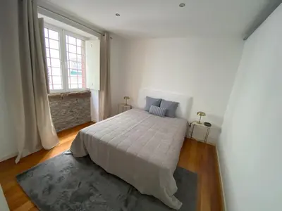 a bedroom with a bed and a large window at Loft Surdo in Funchal