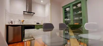 a kitchen with a glass table and green cabinets at Loft Surdo in Funchal