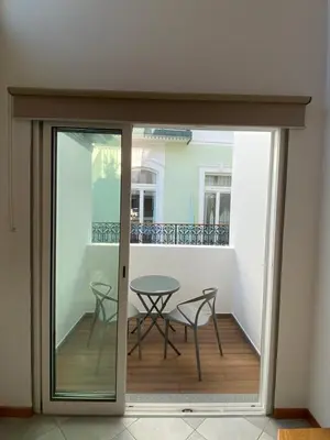 a sliding glass door leading to a balcony with a table at Loft Surdo in Funchal