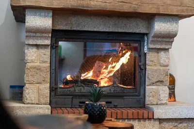 a brick fireplace with a fire in it at Casa do Vale 13 - Ribeiro Frio in São Roque