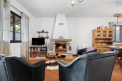 a living room with leather chairs and a fireplace at Casa do Vale 13 - Ribeiro Frio in São Roque