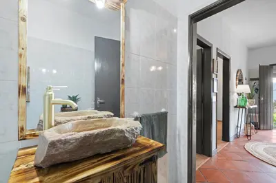 a bathroom with a stone sink and a mirror at Casa do Vale 13 - Ribeiro Frio in São Roque