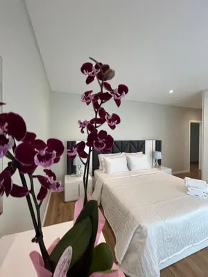 a bedroom with a bed and a purple flower at Saraiva Hills Ocean View Penthouse in Câmara de Lobos