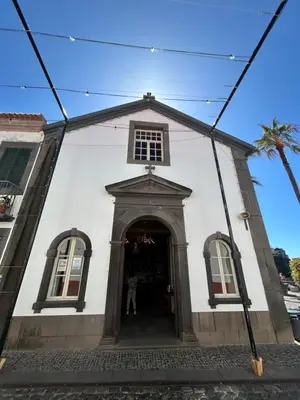 a white building with a doorway with a person standing in it at Saraiva Hills Ocean View Penthouse in Câmara de Lobos